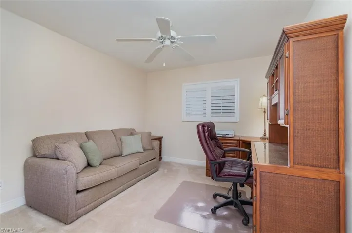 Office with ceiling fan, light colored carpet, and baseboards
