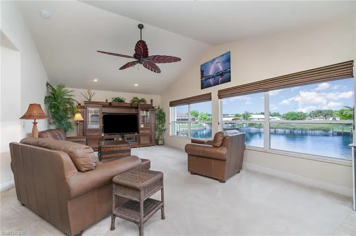 Living area featuring baseboards, a ceiling fan, high vaulted ceiling, and recessed lighting