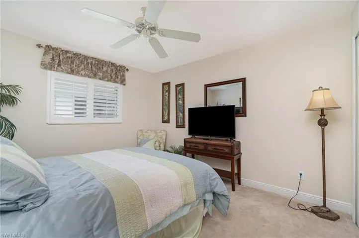 Bedroom with baseboards, ceiling fan, and light carpet