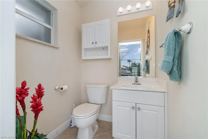 Bathroom with tile patterned floors, vanity, baseboards, and toilet