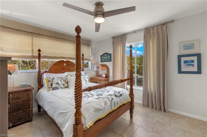 Bedroom with ceiling fan and light tile patterned floors