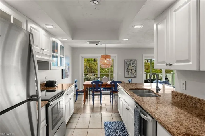 Kitchen featuring stainless steel appliances, recessed lighting, pendant lighting, light tile patterned floors, and white cabinetry