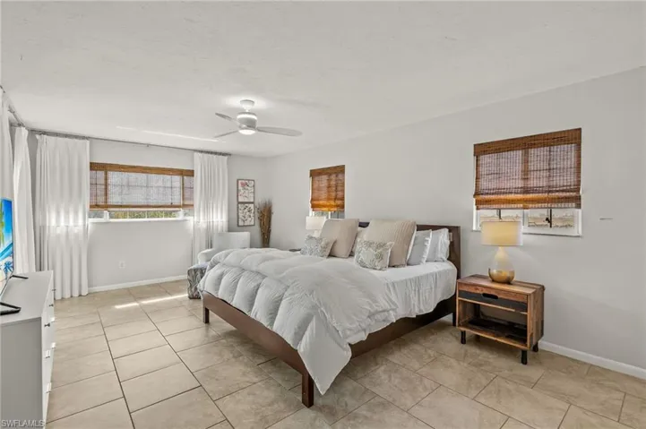 Bedroom with light tile patterned flooring and a ceiling fan