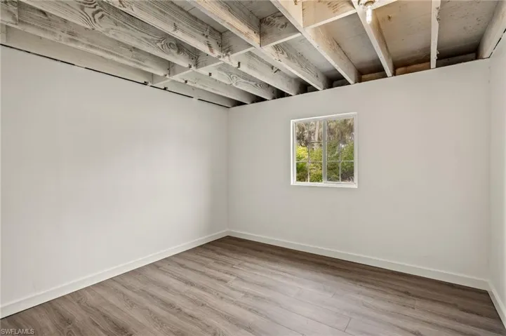 Spare room featuring wood finished floors and baseboards