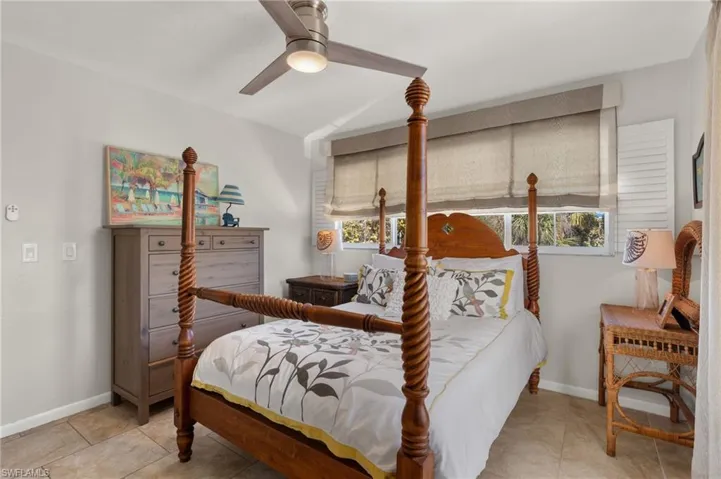 Tiled bedroom with multiple windows and ceiling fan
