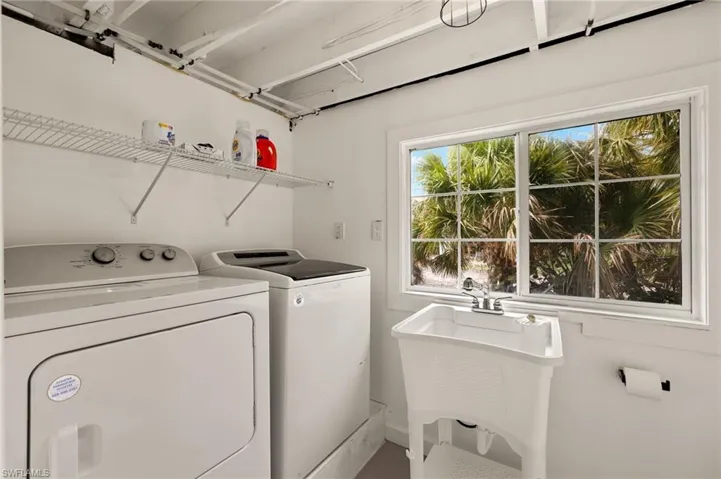 Washroom featuring washer and clothes dryer and a sink