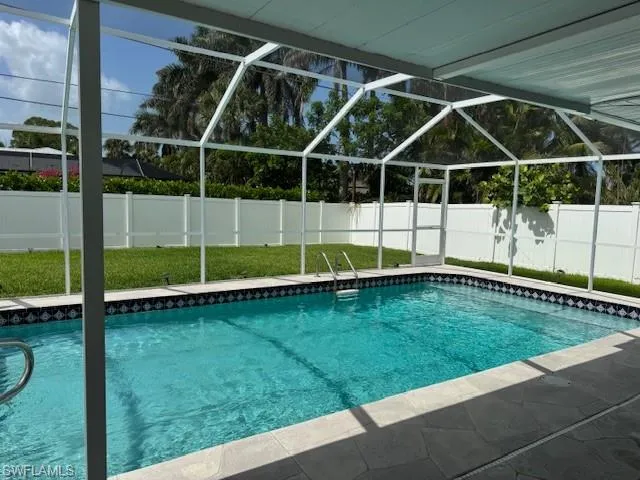 View of swimming pool with a fenced backyard and a lanai