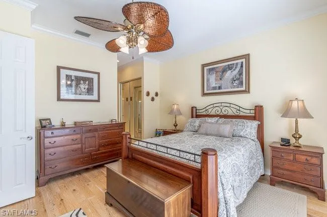 Bedroom featuring light wood-type flooring, ceiling fan, and ornamental molding