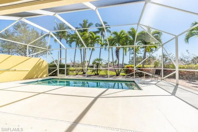 View of swimming pool featuring a lanai and a patio area
