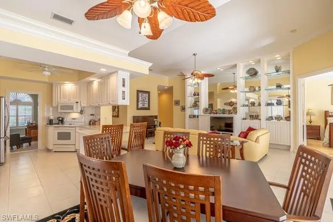 Tiled dining room featuring crown molding
