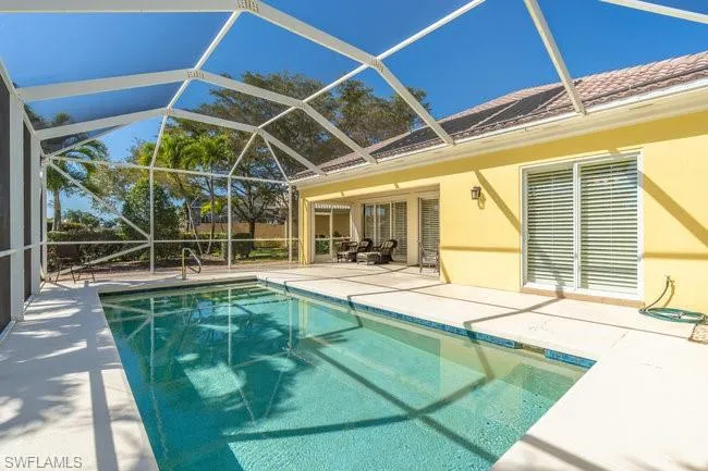 View of swimming pool with a lanai and a patio