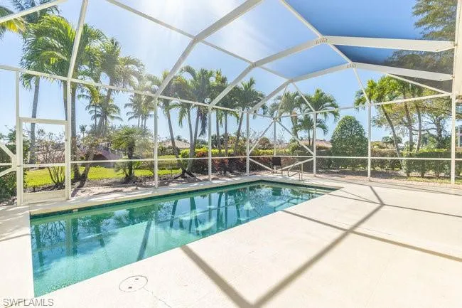 View of pool with a patio area and a lanai