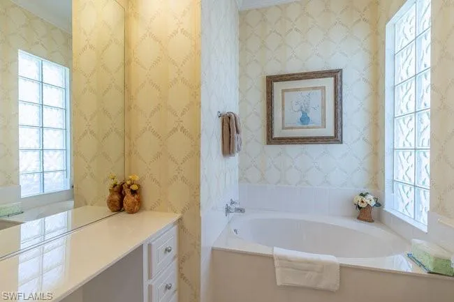 Bathroom featuring a bathtub and crown molding