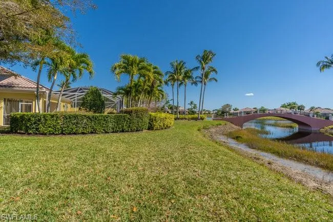 View of yard with a lanai and a water view