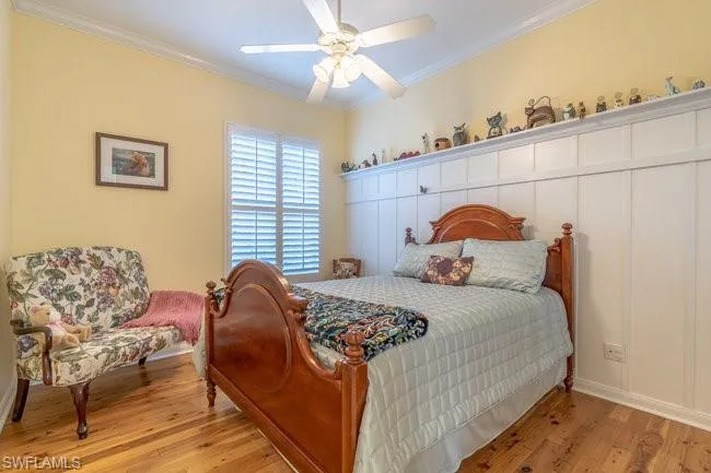 Bedroom featuring ceiling fan, crown molding, and light hardwood / wood-style floors