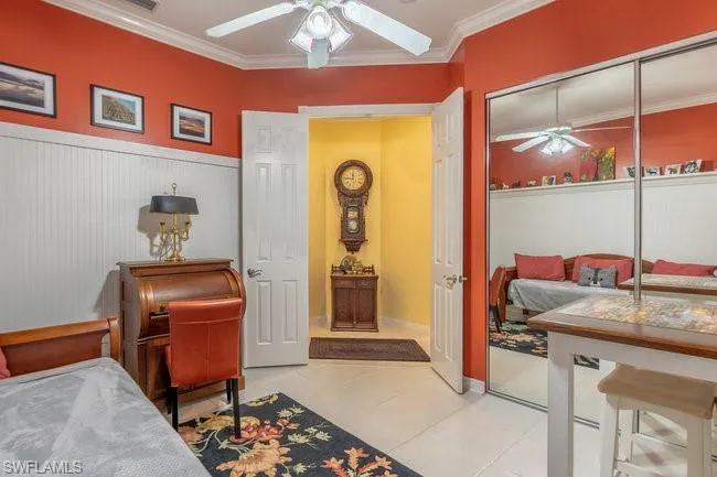 Bedroom with ceiling fan, light tile patterned floors, a closet, and crown molding