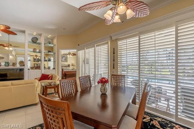 Tiled dining area featuring crown molding and built in shelves