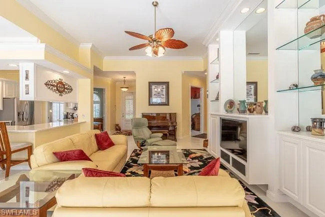 Living room featuring ceiling fan and ornamental molding