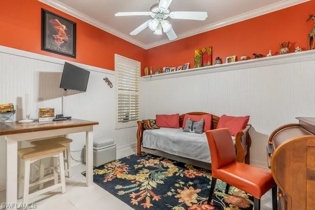 Bedroom with ceiling fan, ornamental molding, and light tile patterned flooring