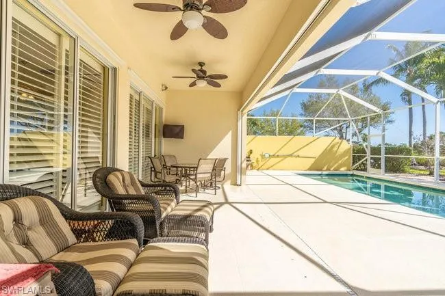 View of patio featuring ceiling fan and glass enclosure