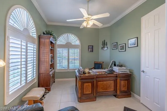 Home office featuring ceiling fan, light tile patterned floors, and ornamental molding