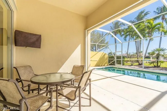 View of swimming pool with a patio area and glass enclosure