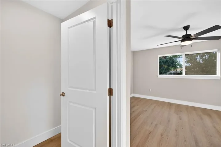 Primary bedroom with baseboards and light wood-type flooring