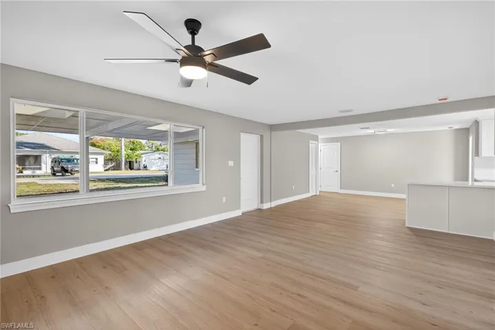 Unfurnished living room with light wood-style floors and a ceiling fan