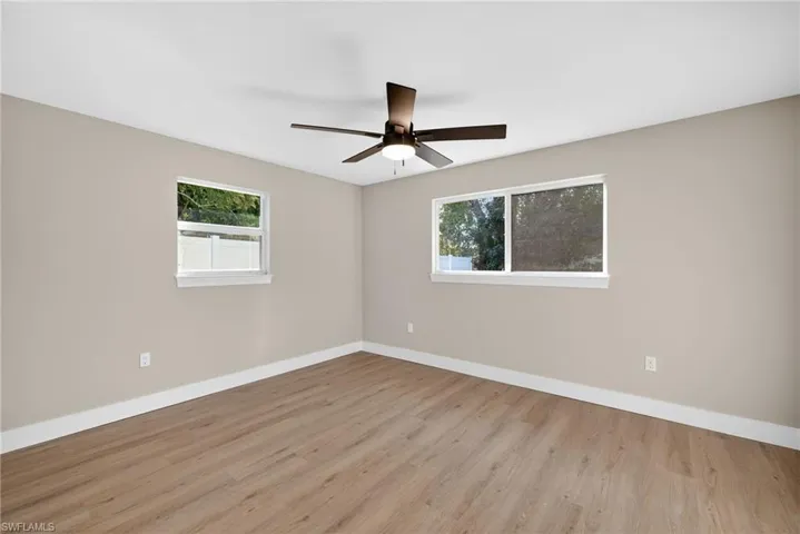 Primary bedroom featuring light wood-style floors and ceiling fan