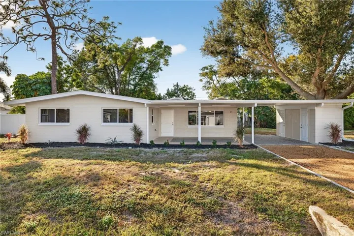 Ranch-style house featuring a front lawn and an attached carport