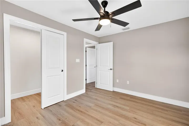 Unfurnished bedroom featuring light wood-type flooring, ceiling fan, and a closet