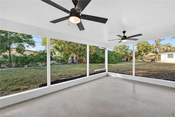 Unfurnished sunroom featuring ceiling fan