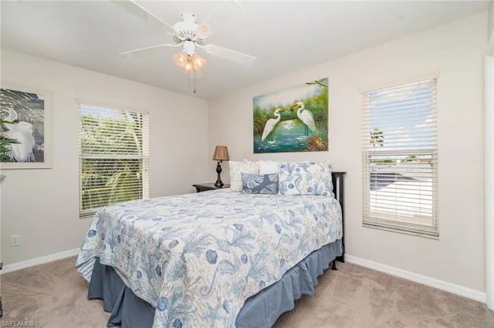 Bedroom #2 with light colored carpet, multiple windows, and ceiling fan