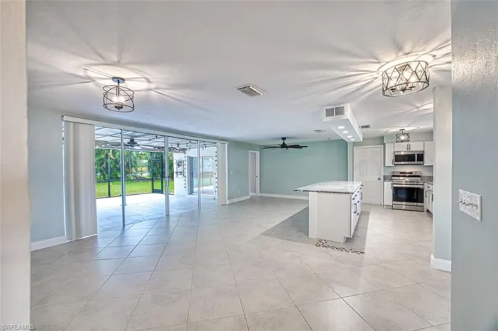 Kitchen with open floor plan, ceiling fan, stainless steel appliances, and visible vents