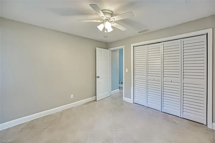 Unfurnished bedroom with a closet, visible vents, ceiling fan, and baseboards