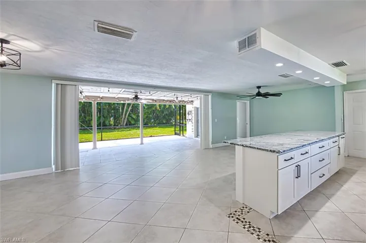 Kitchen featuring visible vents, light tile patterned floors, and white cabinets