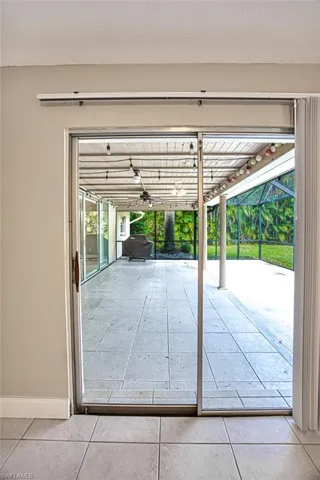 Doorway featuring tile patterned floors and baseboards