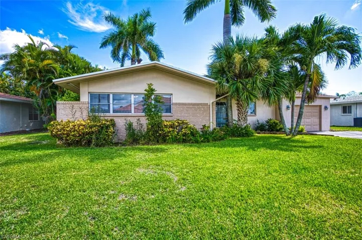 Single story home with a garage, stucco siding, a front yard, and concrete driveway