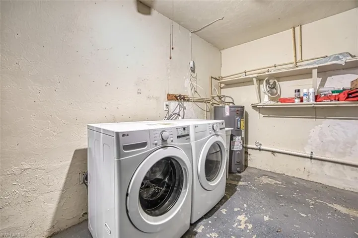 Clothes washing area featuring washer and dryer and water heater