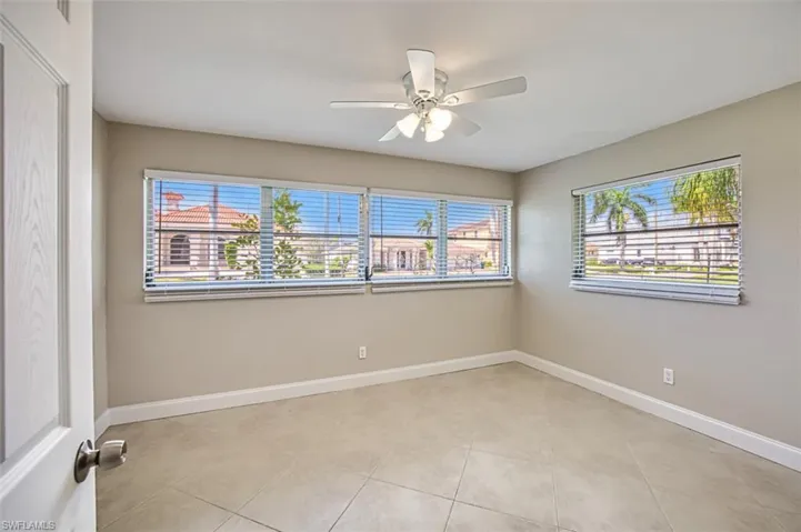 Spare room featuring plenty of natural light, a ceiling fan, and baseboards