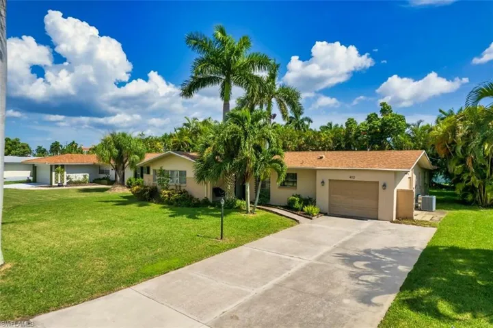 Single story home with a garage, stucco siding, driveway, and a front yard