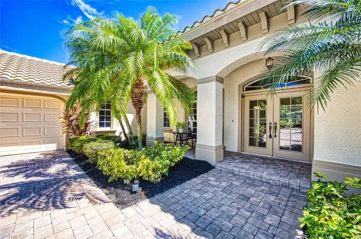 Entrance to property with stucco siding, a garage, french doors, and decorative driveway