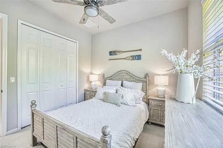 Bedroom featuring light carpet, a closet, and a ceiling fan