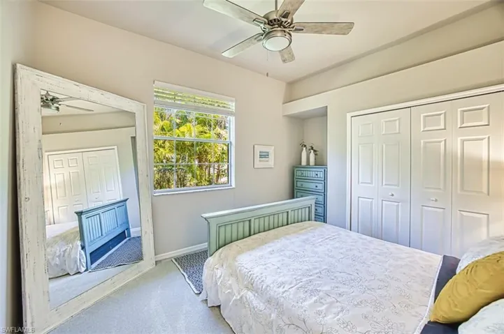 Bedroom featuring light colored carpet, a closet, baseboards, and a ceiling fan