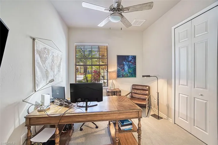 Office with baseboards, visible vents, ceiling fan, and carpet
