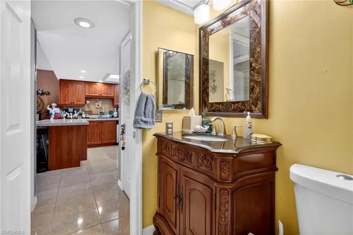 Half bath featuring vanity, recessed lighting, and light tile patterned floors