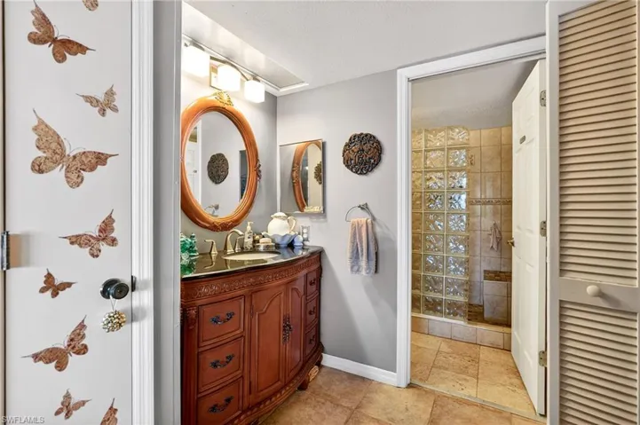 Full bathroom featuring vanity, a closet, a stall shower, and a textured ceiling