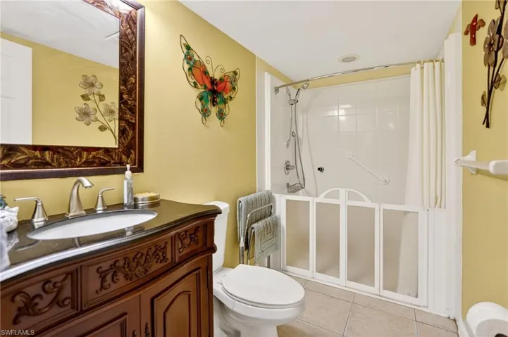 Bathroom featuring vanity, a stall shower, and light tile patterned floors