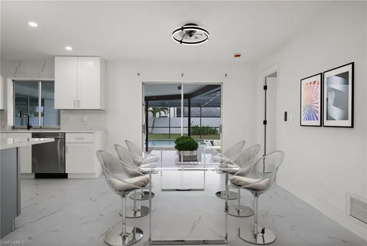 Dining space featuring light marble finish floors and recessed lighting