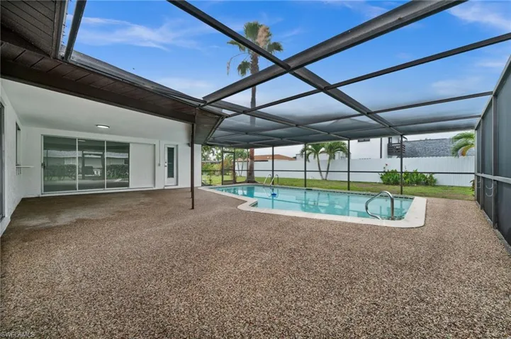 View of swimming pool with a patio area, a fenced backyard, and glass enclosure